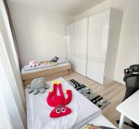 Kinderzimmer in einer 3-Zimmer-Wohnung mit Spielzeug und einem Boden in Holzoptik.
