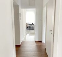 Der Flur der 3-Zimmer-Wohnung mit einem Holzboden führt ins Esszimmer.