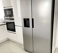 Küche in einer 3-Zimmer-Wohnung mit einem Kühlschrank aus Edelstahl und Keramikfliesen.
