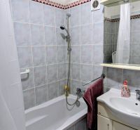 Badezimmer in einer 2-Zimmer-Wohnung mit Badewanne, Waschbecken und Keramikfliesen.
