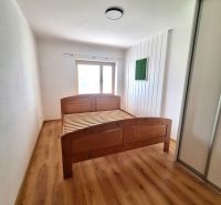 Schlafzimmer mit Holzbett und Einbauschrank in einer 2-Zimmer-Wohnung.