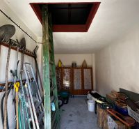 Ein Lagerraum mit Werkzeugen im Einfamilienhaus, mit Zugang zum Dachboden über eine Leiter.