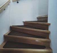 Innenraum mit Holztreppe und Geländer in einem Einfamilienhaus.