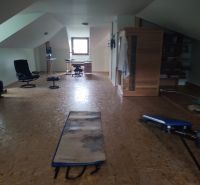 Dachbodenraum in einem Einfamilienhaus mit Holzboden und Fitnessgeräten.