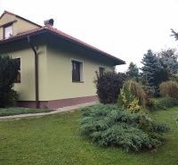 Ein Einfamilienhaus in Trebostovo mit einem gepflegten Garten und Holzelementen am Dach.