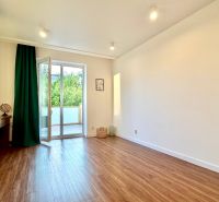 Helles Zimmer mit Zugang zum Balkon, Holzboden in einer 3-Zimmer-Wohnung.