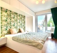 Schlafzimmer in einer 3-Zimmer-Wohnung mit Holzboden und grünem Vorhang.