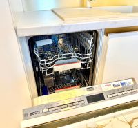 Die Spülmaschine in der Küche einer 3-Zimmer-Wohnung, offene Tür zeigt das Innere.