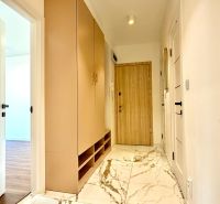 Der Flur in der 3-Zimmer-Wohnung mit weißen Türen und einem Boden mit Marmordekor.