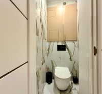 Badezimmer in einer 3-Zimmer-Wohnung mit Fliesen in Marmoroptik und hängendem WC.