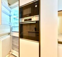Küchenzeile mit Kühlschrank und eingebauten Geräten in einer 3-Zimmer-Wohnung.