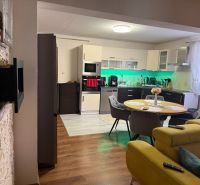 Küche mit Esstisch und Sofa, Boden mit Holzdekor in einem Einfamilienhaus.