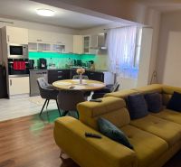 Küche und Wohnzimmer in einem Einfamilienhaus mit Holzboden und einem bequemen Sofa.