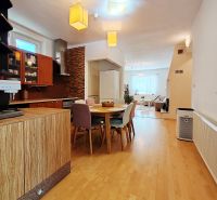 Küche in einem Einfamilienhaus mit Holzboden, Tisch und Geräten.