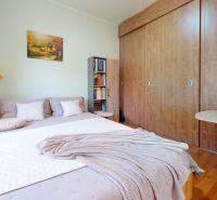 Ein Schlafzimmer in einem Einfamilienhaus mit einem großen Bett, einer Lampe und einem Schrank mit Holzdekor.