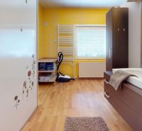 Ein Badezimmer in einem Einfamilienhaus mit einem Boden in Holzoptik, gelben Fliesen und einem Waschbecken.