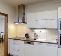 Küche einer 3-Zimmer-Wohnung mit weißen Schränken und Holzboden-Dekor.
