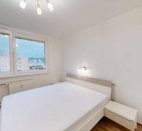 Helles Schlafzimmer mit Bett, Blick aus dem Fenster und Holzboden in einer 3-Zimmer-Wohnung.