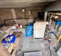 Technikraum in einem Einfamilienhaus mit Kessel und Leitungen, Stauraum für Materialien.