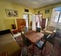 Wohnzimmer eines Einfamilienhauses mit Teppich, Holzmöbeln und Wandmalereien.