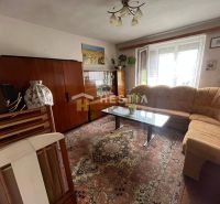 Wohnzimmer in einem Einfamilienhaus mit Teppich und verglastem Vitrinenschrank.