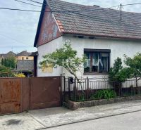 Ein Einfamilienhaus in Cerová mit einem Tor und einem kleinen Garten, umgeben von Grün.