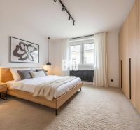 Schlafzimmer mit Doppelbett, hellen Wänden, Teppichboden und Wanddekoration in einer 4-Zimmer-Wohnung.