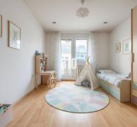 Kinderzimmer in einer 4-Zimmer-Wohnung mit bunten Möbeln und einem Boden in Holzoptik.