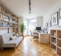 Arbeitszimmer in einer 4-Zimmer-Wohnung mit Bibliothek, Pflanze und Holzboden.
