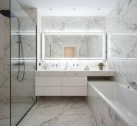 Ein Badezimmer mit Marmorfliesen, Dusche, Badewanne und einem großen Spiegel in einer 4-Zimmer-Wohnung.