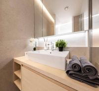 Badezimmer mit modernem Waschbecken, Handtüchern und Dekoration in einer 3-Zimmer-Wohnung.