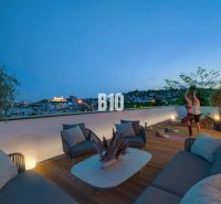 Eine Terrasse mit Blick auf die Stadt, bequeme Sitzgelegenheiten und trainierende Menschen in einer 3-Zimmer-Wohnung.