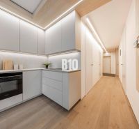 Küche in einer 3-Zimmer-Wohnung mit Holzboden und hellen Möbeln.