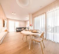 Wohnzimmer in einer 3-Zimmer-Wohnung mit Holzboden, Esstisch und Sofa.