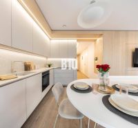 Eine stilvolle Küche in einer 3-Zimmer-Wohnung mit Holzboden und modernen Möbeln.