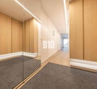 Flur in einer 3-Zimmer-Wohnung mit Holzboden und Spiegel.