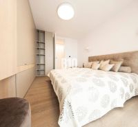 Helles Schlafzimmer mit Holzboden und Einbauschränken in einer 3-Zimmer-Wohnung.