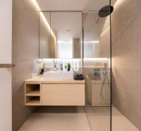 Badezimmer mit Spiegel, Dusche und Holzelementen in einer 3-Zimmer-Wohnung.