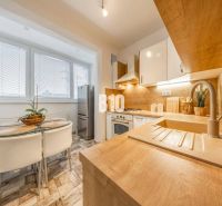 Küche in einer 2-Zimmer-Wohnung mit Holzboden und Essecke.