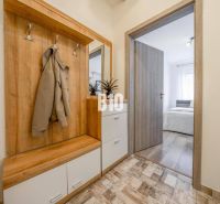 Eingangsflur mit Garderobenwand und Blick ins Schlafzimmer in einer 2-Zimmer-Wohnung.