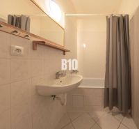 Badezimmer mit Duschvorhang und Waschbecken im Büro.