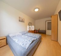 Ein Schlafzimmer mit zwei Betten, einem Nachttisch, einem Schrank und einem Fernseher an der Wand.
