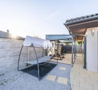 Ein Einfamilienhaus in Most pri Bratislave mit Terrasse, einem Außenfitnessstudio und einer Schaukel.