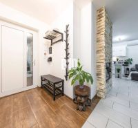 Innenraum eines Einfamilienhauses mit Holzboden, Steinkamin und gemütlichem Wohnzimmer.