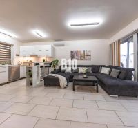 Helles Wohnzimmer in einem Einfamilienhaus mit Küche und großem Sofa.