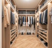 Ein Kleiderschrank mit einem Boden in Holzdekor, der Kleidung und Schuhe in einer 4-Zimmer-Wohnung enthält.
