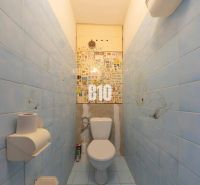 Badezimmer in einer 4-Zimmer-Wohnung mit blauen Fliesen und Toilette.