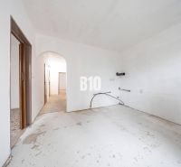 Neingerichtetes Zimmer in einer 4-Zimmer-Wohnung mit weißen Wänden und Betonboden.
