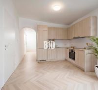 Küche in einer 4-Zimmer-Wohnung mit Holzboden und hellen Möbeln.