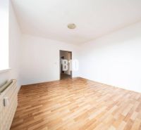 Helles Zimmer mit Wänden in einer 4-Zimmer-Wohnung und einem Boden mit Holzdekor.